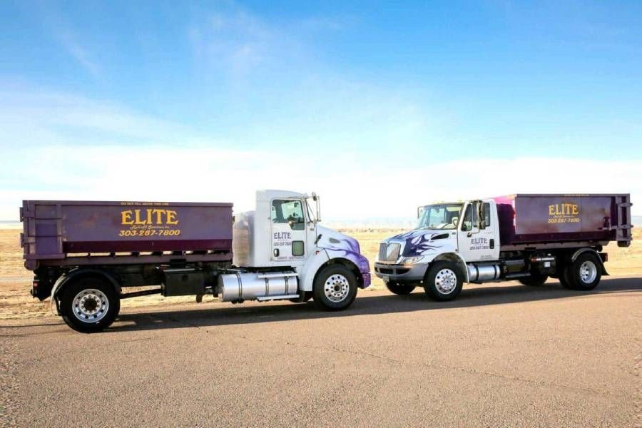 A large purple dumpster is in front of a house.