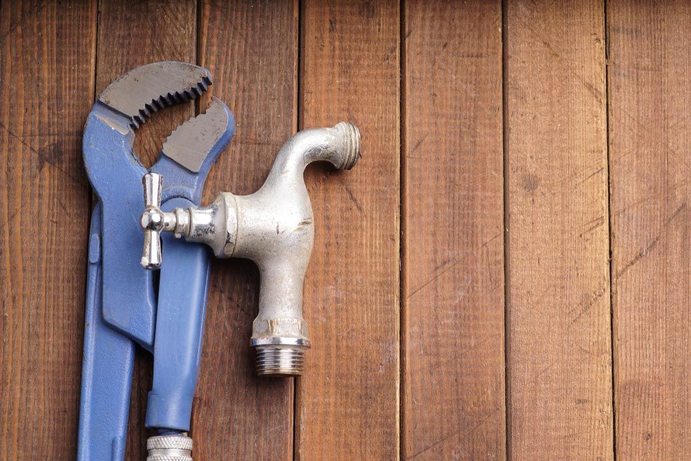 Expert Plumbing Services Featuring a Wrench And Vintage Faucet — Town & Country Plumbing Victoria in Bacchus Marsh, VIC