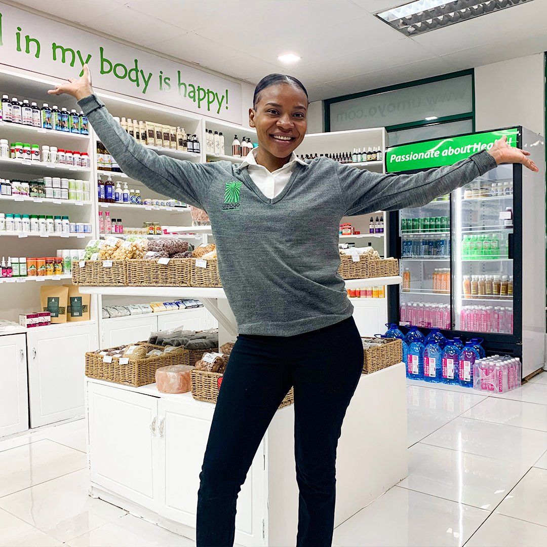 A woman is standing in a store with her arms outstretched.
