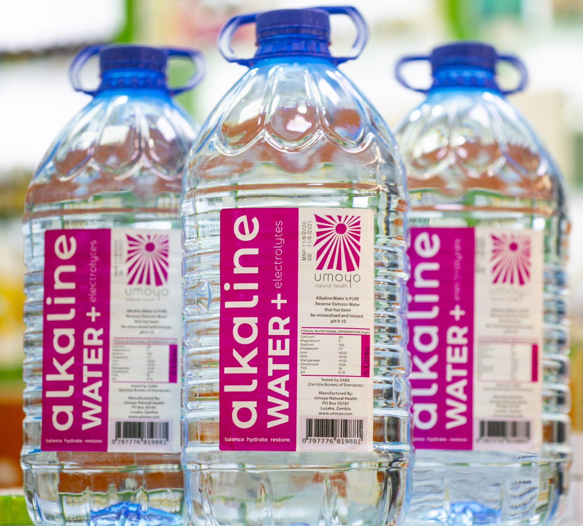 Three bottles of alkaline water are lined up on a table.
