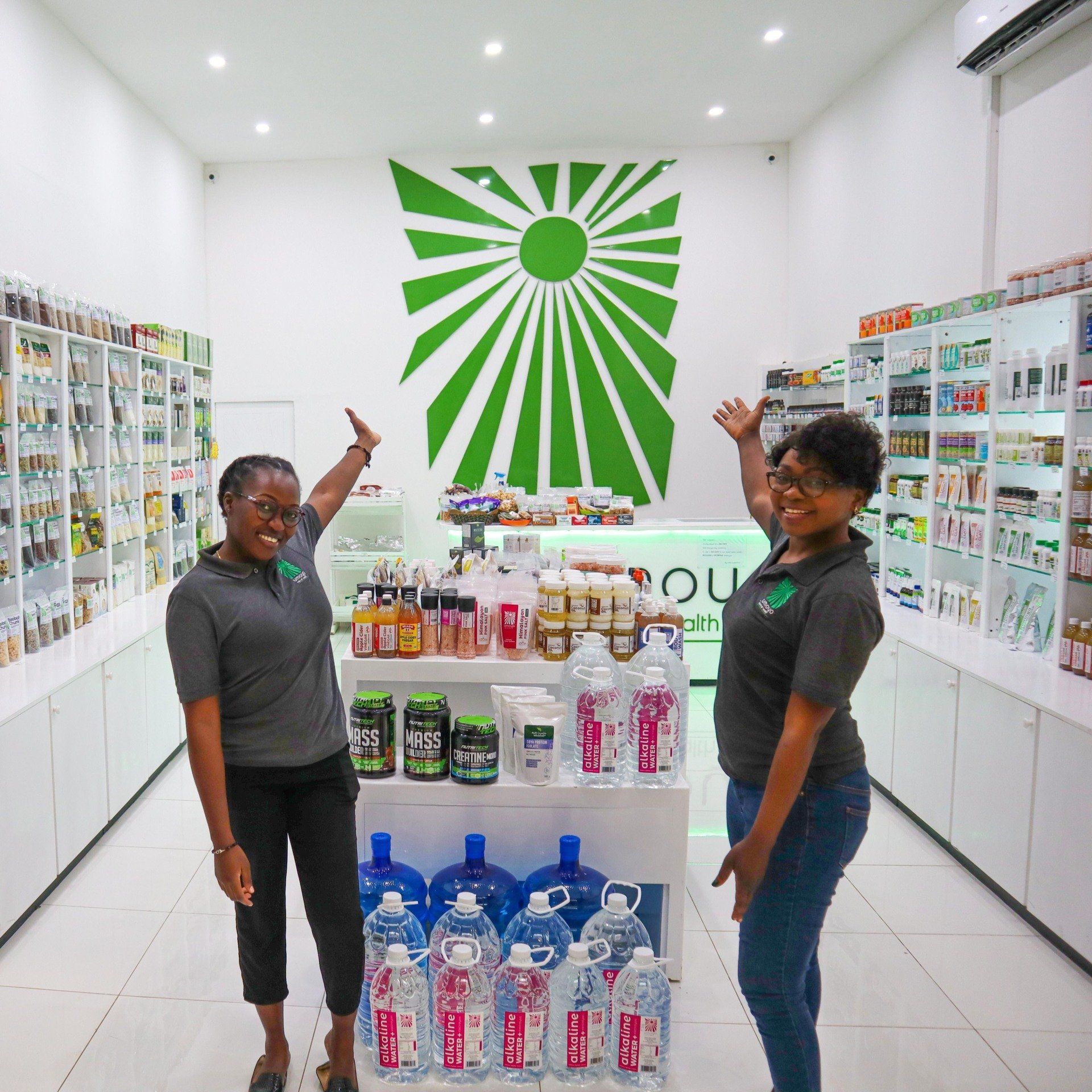 Two women standing in a store with a green sun on the wall