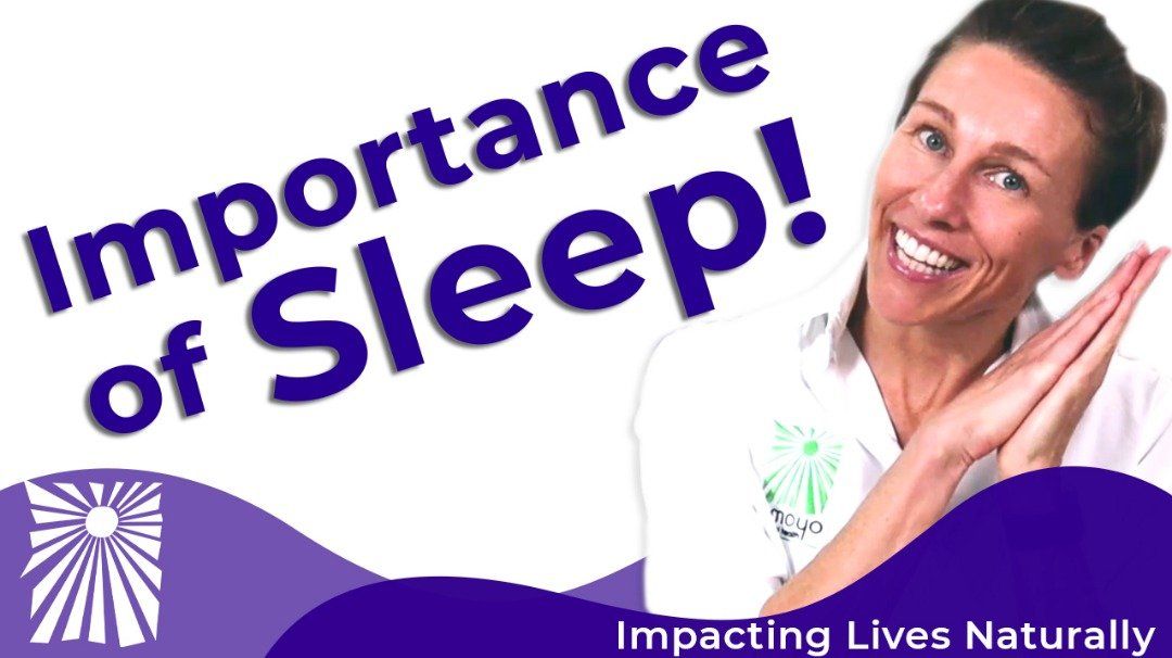 A woman is smiling in front of a sign that says importance of sleep