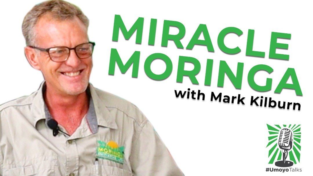 A man is smiling in front of a sign that says miracle moringa with mark kilburn