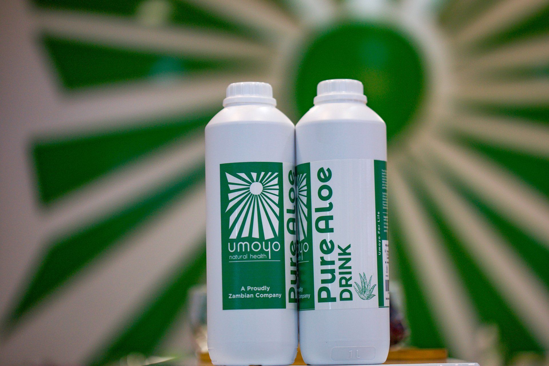 Two bottles of pure aloe drink are sitting on a table.