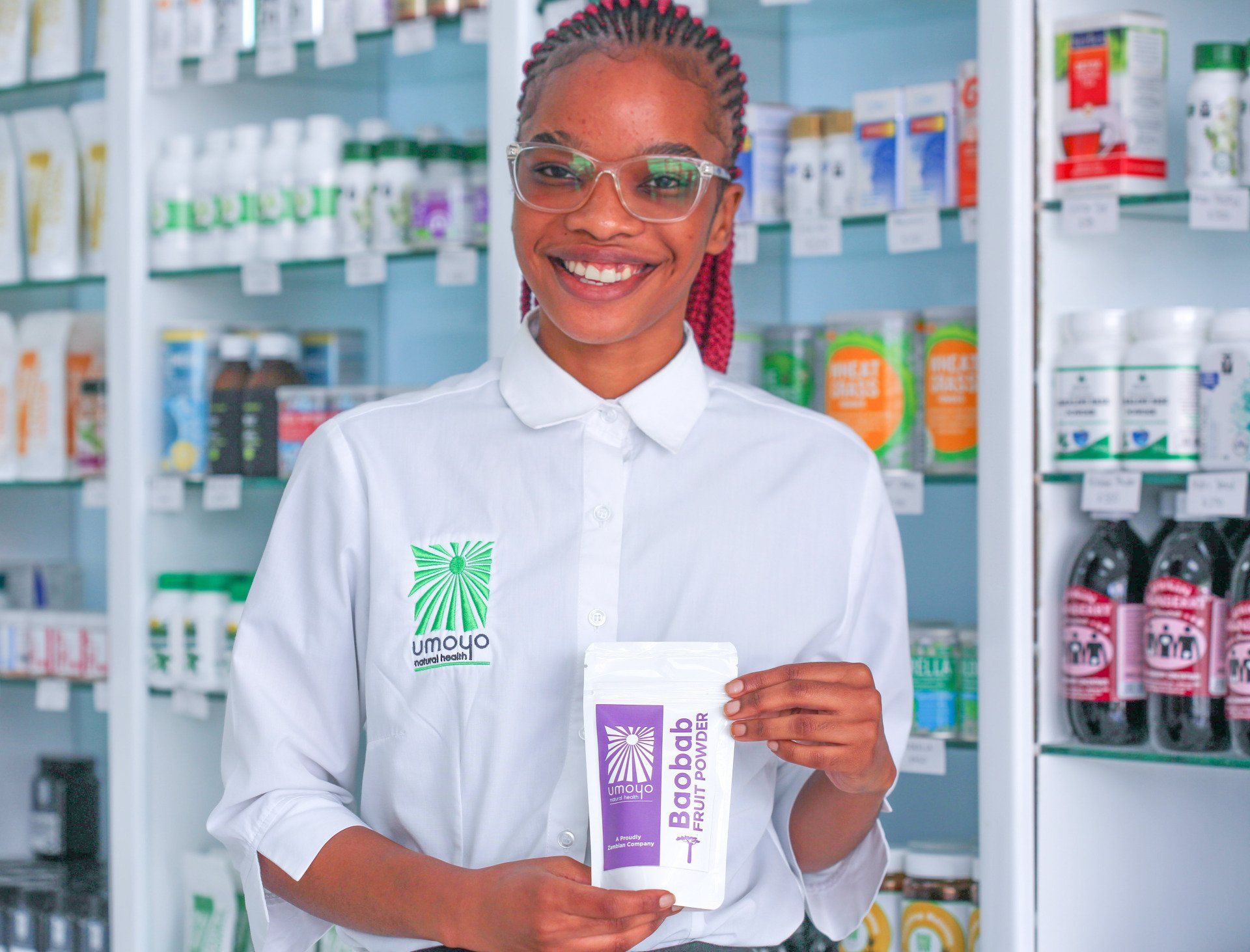 A woman is holding a box of wipes in a pharmacy.