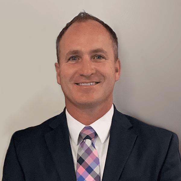 A man in a suit and tie is smiling for the camera.