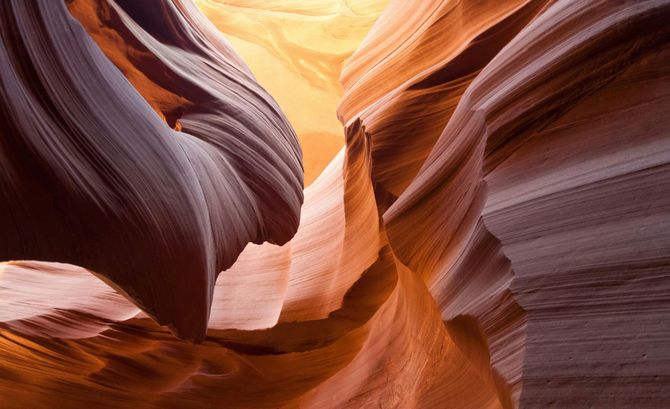 A close up of a canyon with the sun shining through it