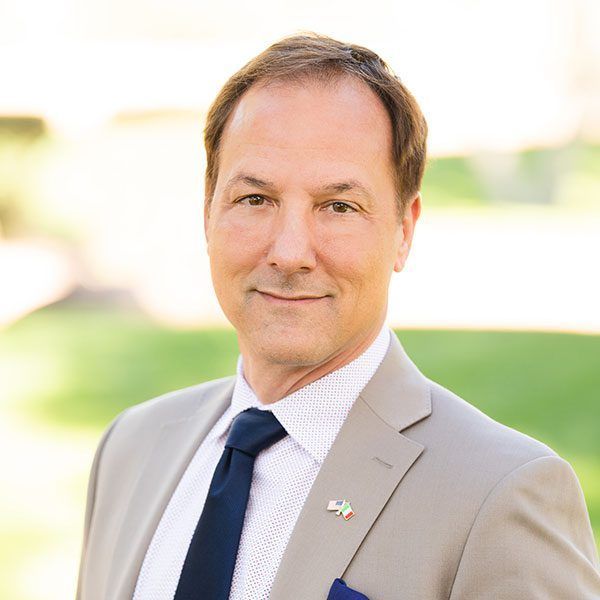 A man in a suit and tie is smiling for the camera