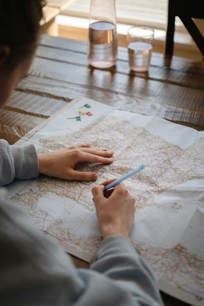 A person is sitting at a table looking at a map.