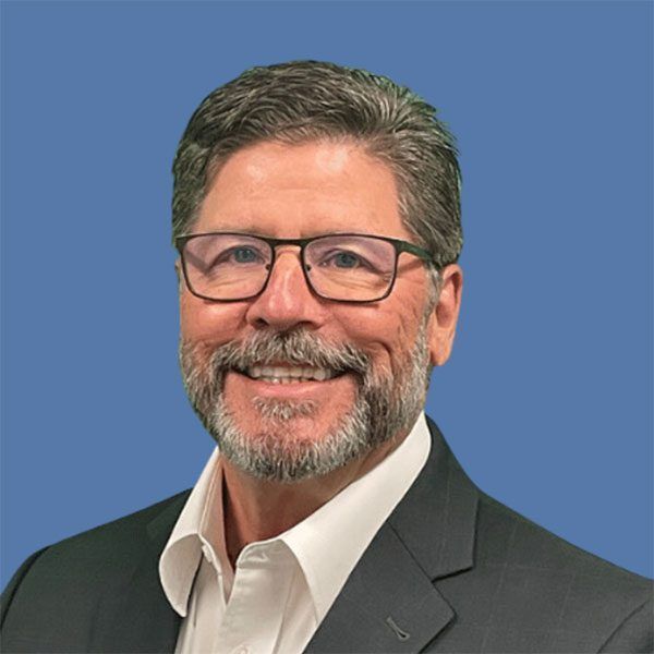 A man with glasses and a beard is smiling for the camera