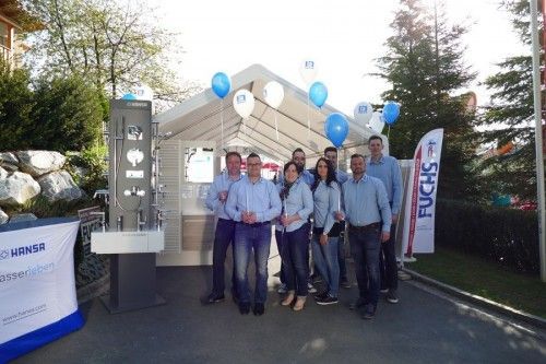 Eine Gruppe von Menschen posiert vor einem Zelt für ein Foto.