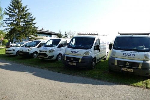 Eine Reihe von Lieferwagen, die am Straßenrand geparkt sind.