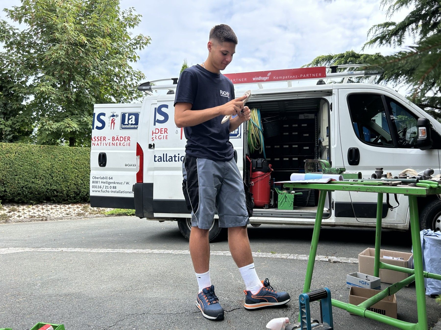 Ein junger Mann steht vor einem weißen Lieferwagen.