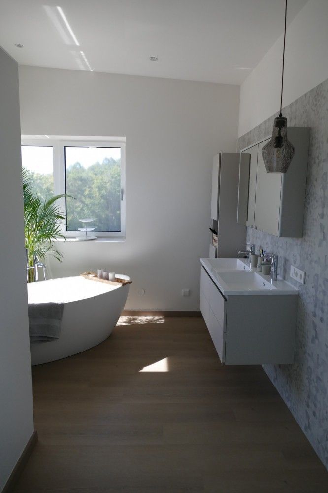 Ein Badezimmer mit Badewanne, Waschbecken, Spiegel und Fenster.