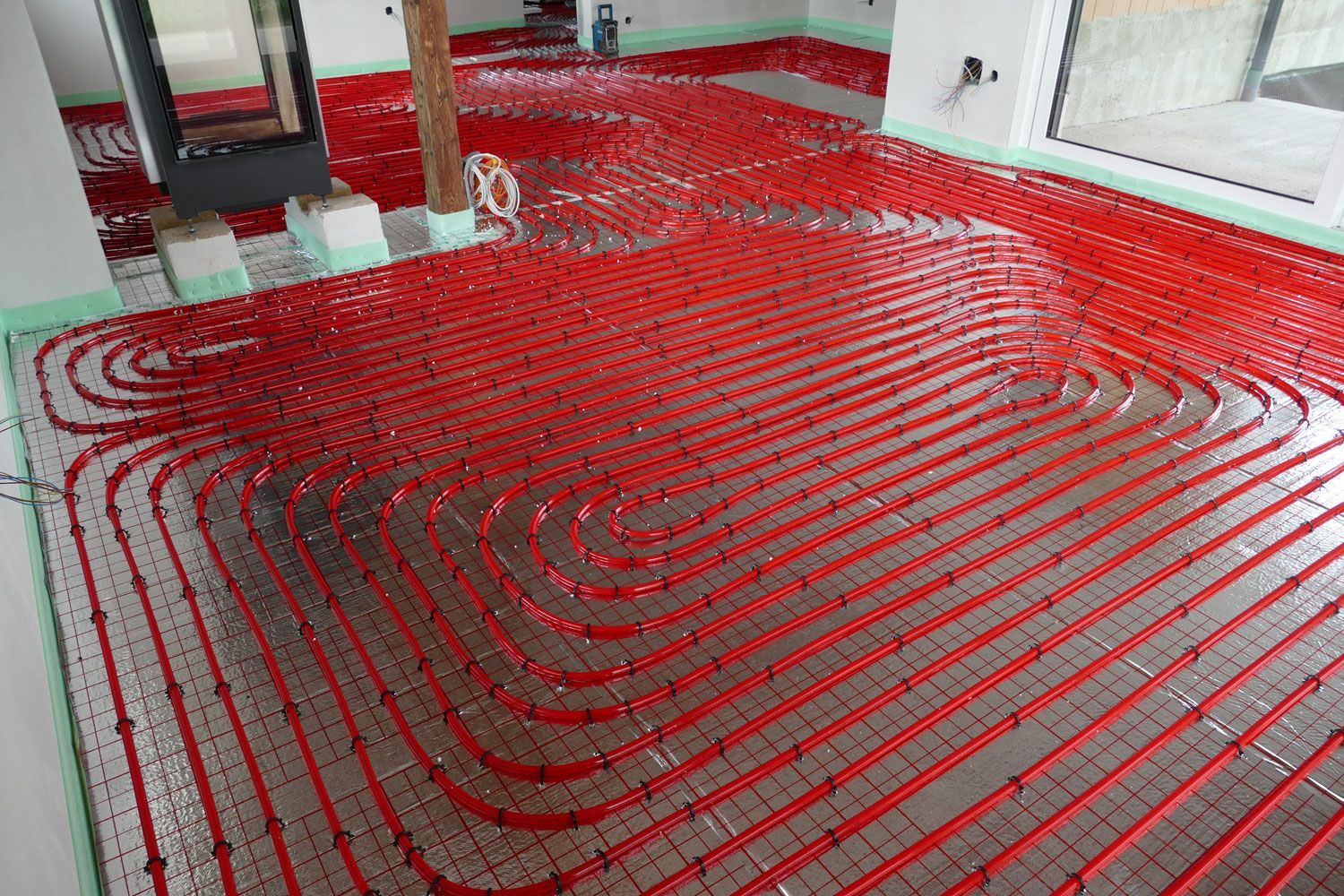 In einem Raum wird eine rote Fußbodenheizung installiert.