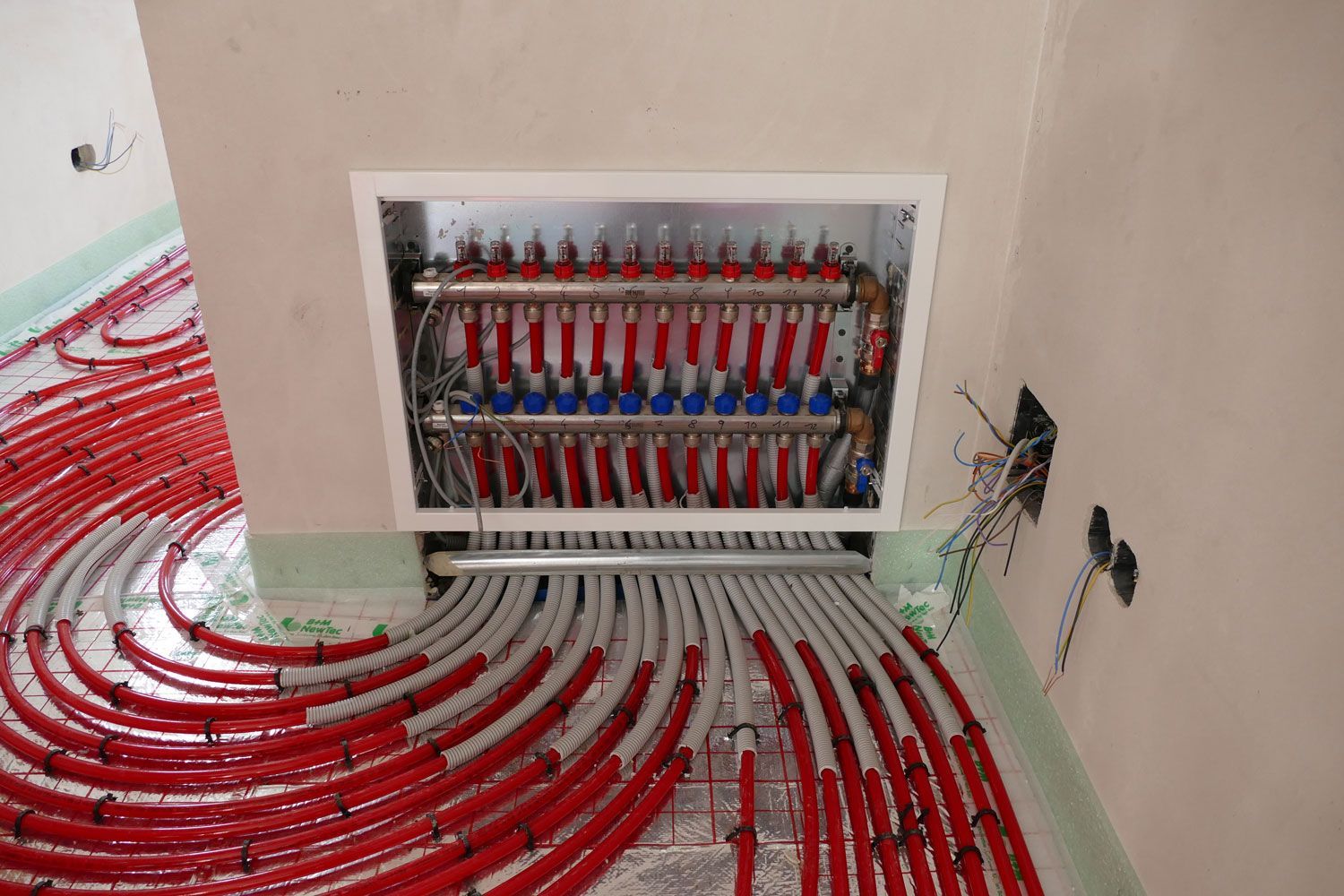 Ein Raum mit vielen roten und weißen Rohren auf dem Boden.