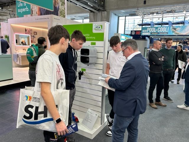 Ein Mann im Anzug spricht mit einem Jungen in einer weißen Plastiktüte