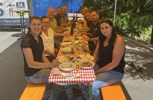 Eine Gruppe von Menschen sitzt an einem langen Tisch und isst.