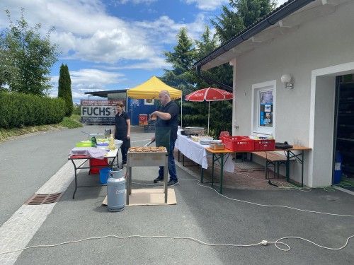 Ein Mann steht vor einem Gebäude vor einem Tisch.