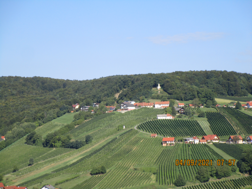 Ein Bild von einem Hügel mit ein paar Häusern darauf
