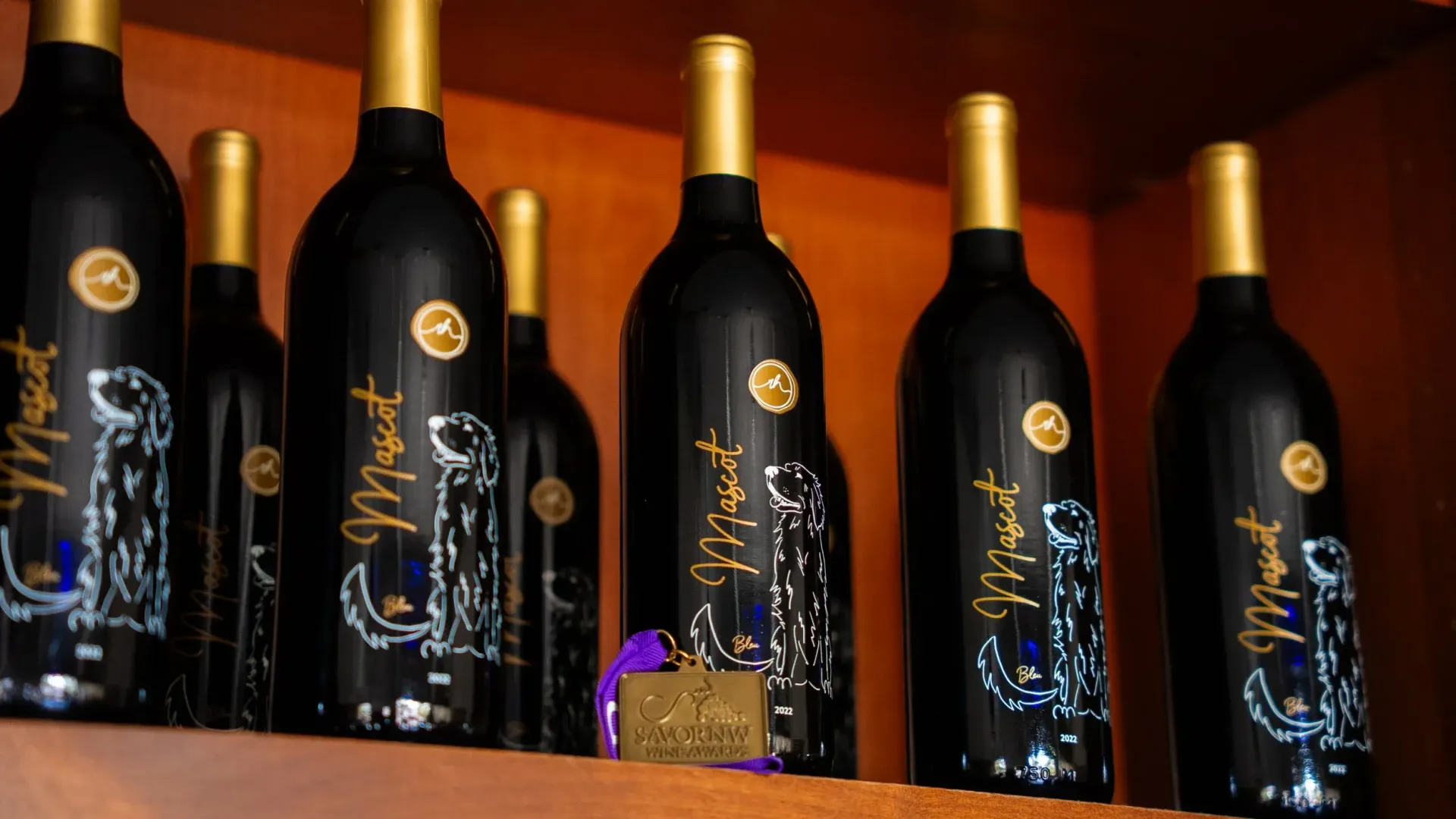 Wine bottles on a shelf. Black bottles with gold caps, labels with dog illustration.