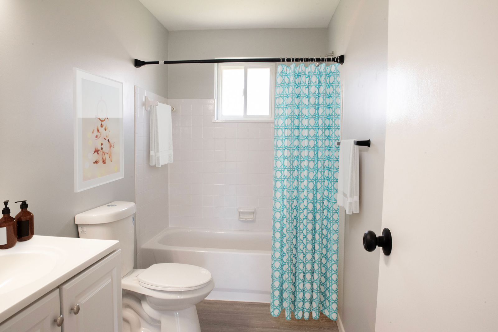 A bathroom with a toilet , sink , tub and shower curtain.