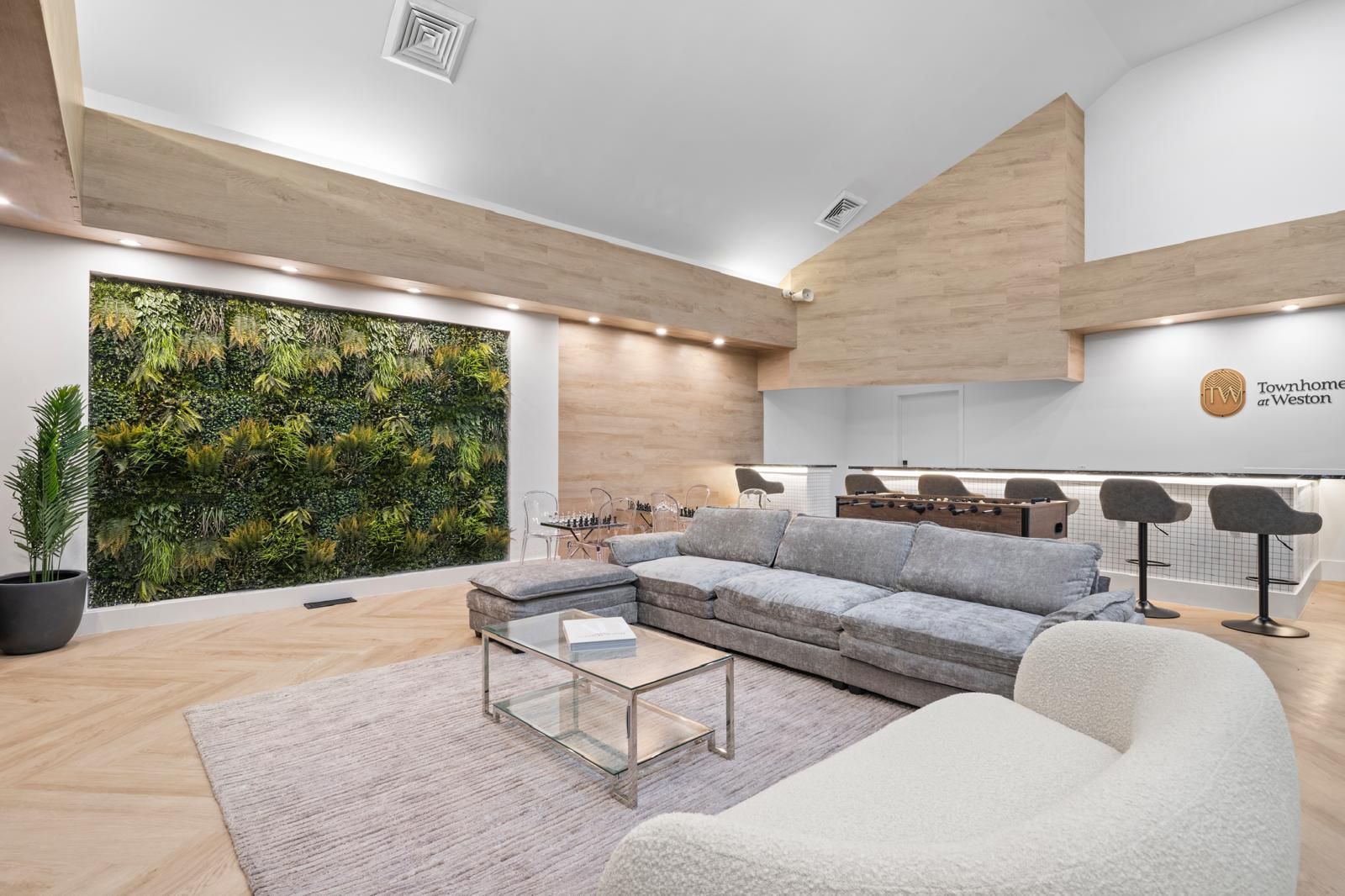 A living room with a couch , chair , coffee table and a green wall.