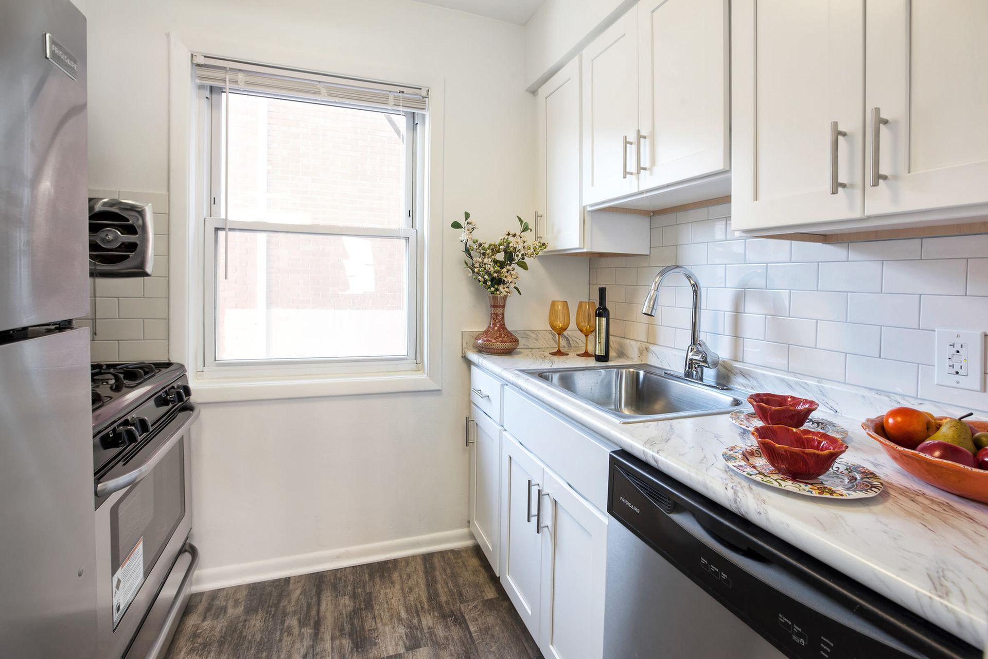 Compact white kitchen with marble-like countertop, stainless steel sink, window, and appliances. Ready to make Joralemon your home? Contact us today to learn more about our pet-friendly 1, 2, and 3-bedroom apartments for rent in Belleville, NJ. We can’t wait to welcome you home!