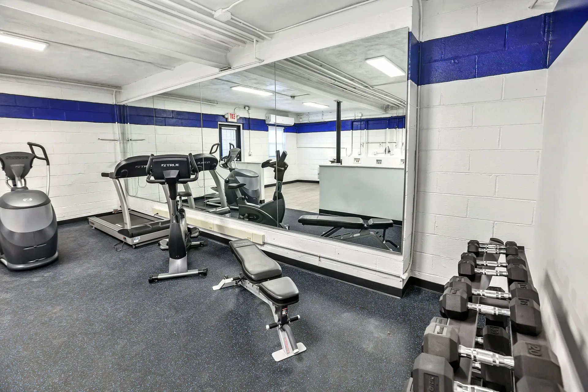 Indoor gym with cardio machines, free weights, and a large wall mirror. 
Ready to make Joralemon your home? Contact us today to learn more about our pet-friendly 1, 2, and 3-bedroom apartments for rent in Belleville, NJ. We can’t wait to welcome you home!