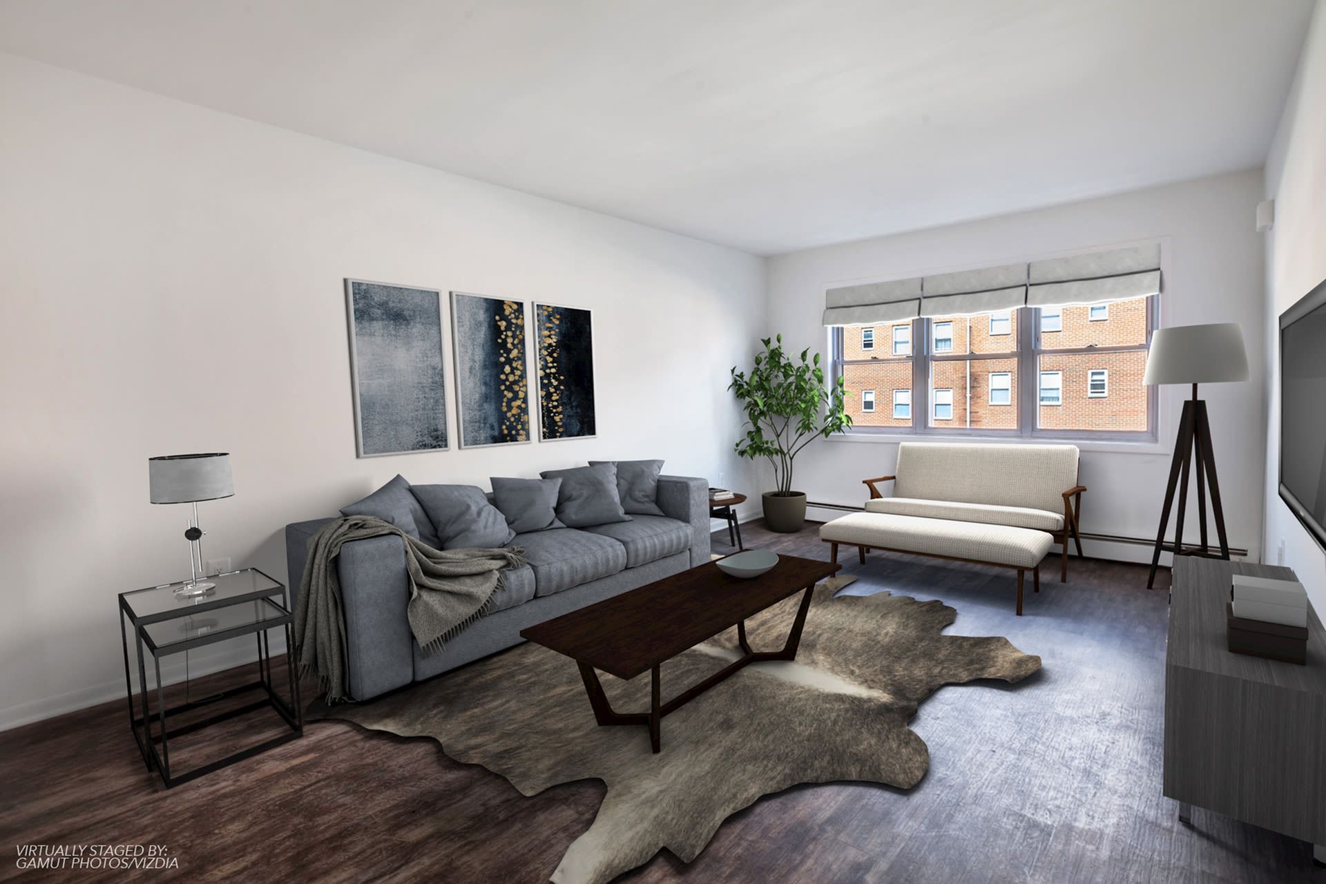 Modern living room with gray sofa, a light chair, coffee table, rug, and a large window. Ready to make Joralemon your home? Contact us today to learn more about our pet-friendly 1, 2, and 3-bedroom apartments for rent in Belleville, NJ. We can’t wait to welcome you home!