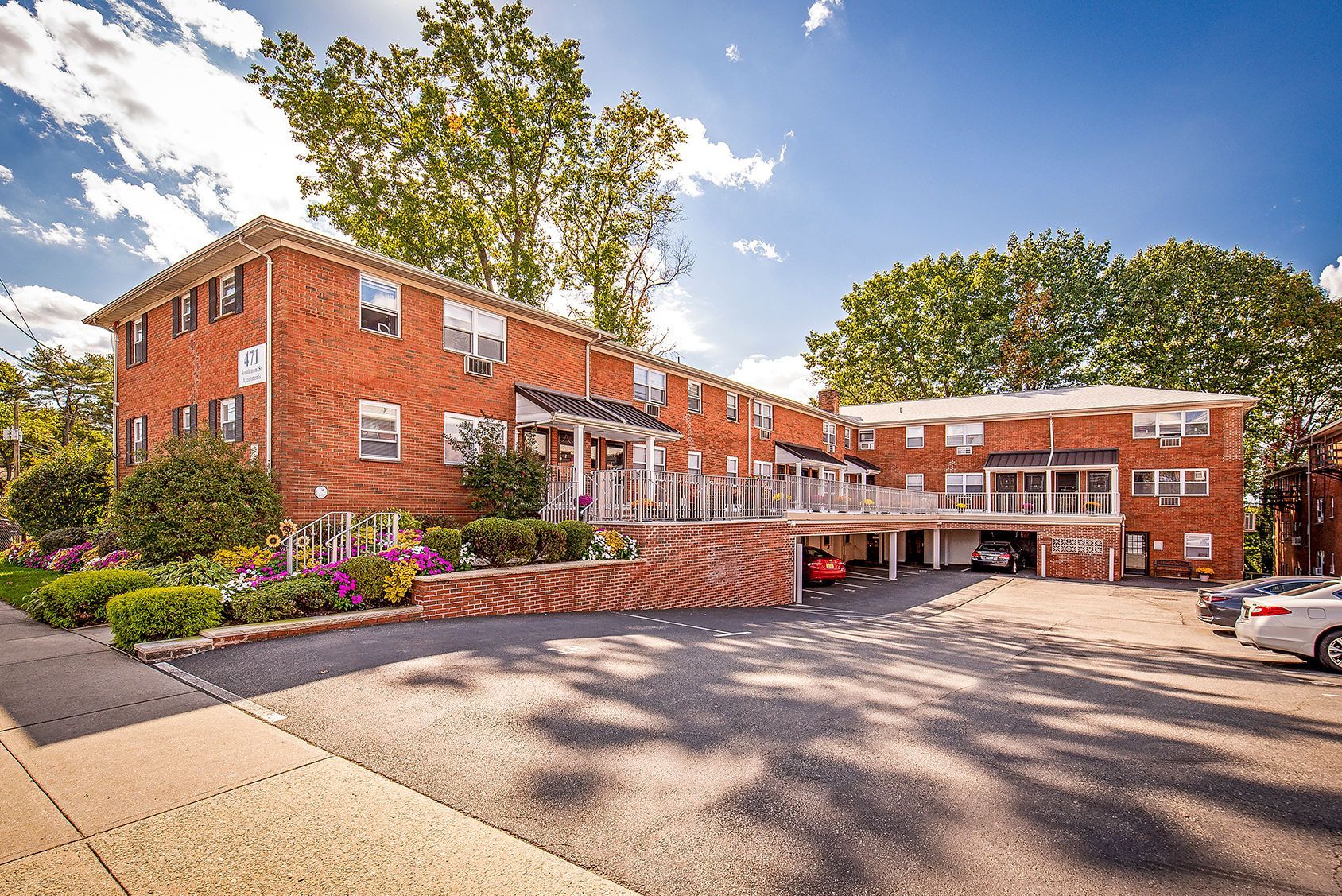 Exterior view of a brick apartment building with landscaped entry and parking area. Ready to make Joralemon your home? Contact us today to learn more about our pet-friendly 1, 2, and 3-bedroom apartments for rent in Belleville, NJ. We can’t wait to welcome you home!