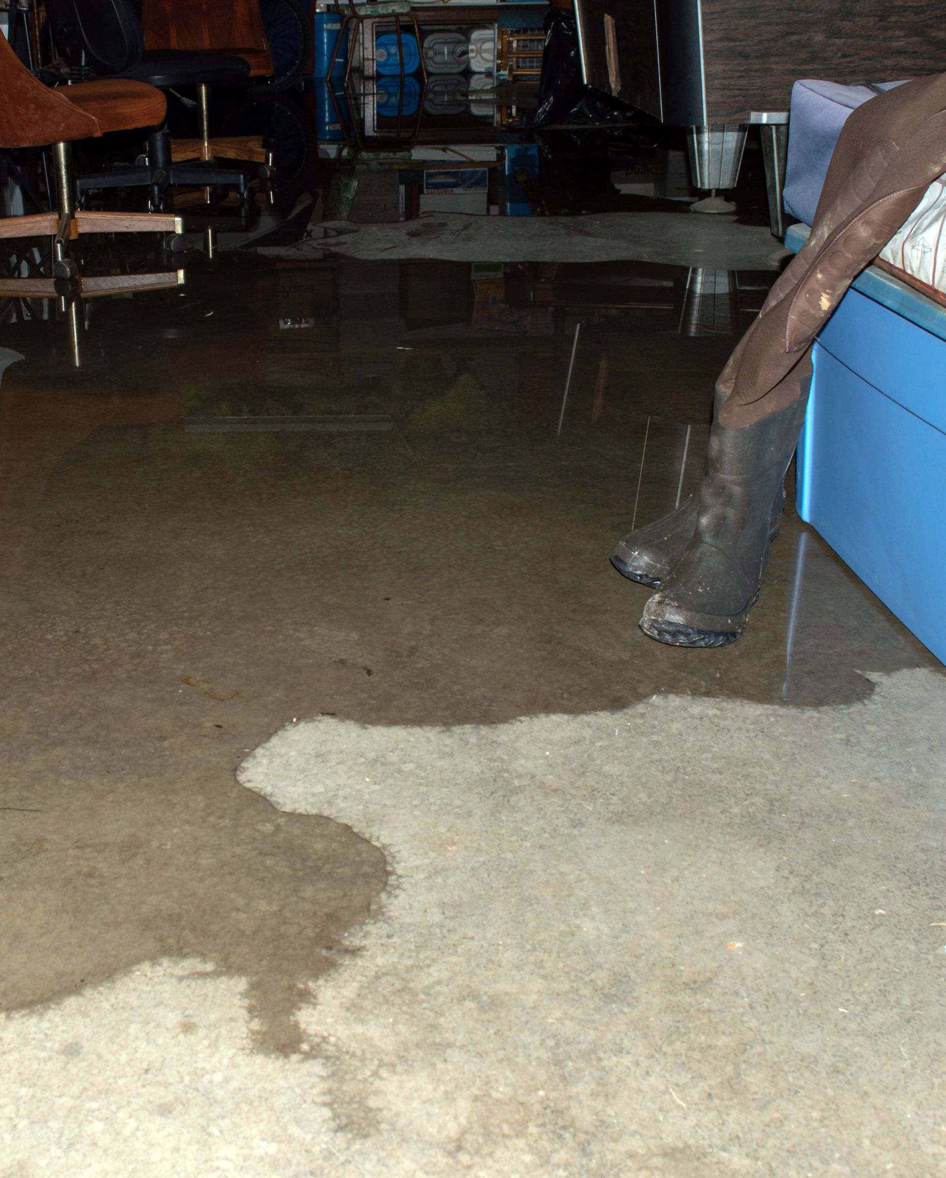 A person 's feet are standing in a flooded room