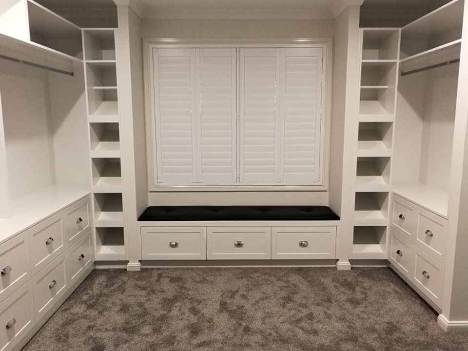 White Built-in Closet With Shelves, Drawers, and Window Seat With Black Cushion. Gray Carpet — Payton Kitchens in Gatton, QLD