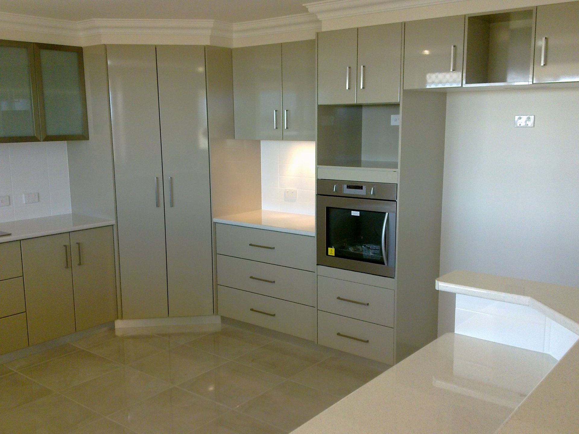 Kitchen With Light-colored Glossy Cabinets — Payton Kitchens In Wilsonton, QLD