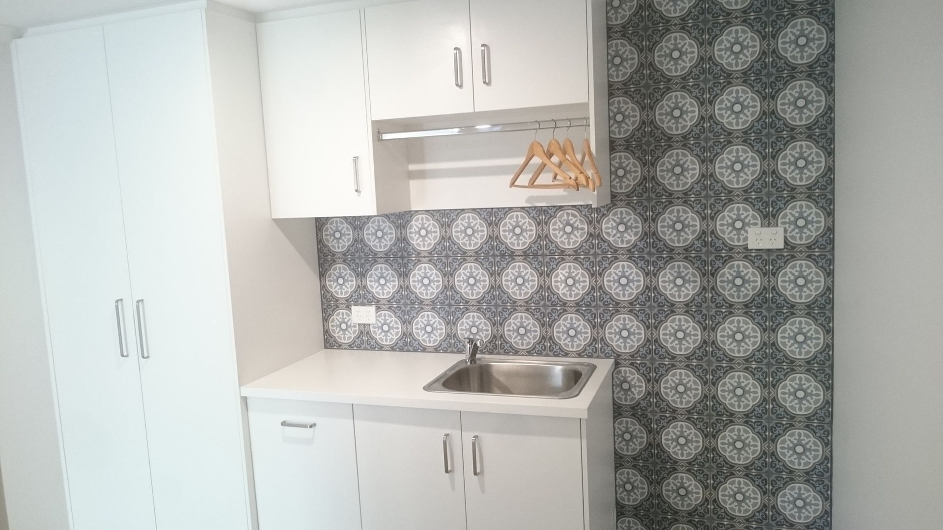 White Laundry Room With Sink, Cabinets, Patterned Backsplash, and Hanging Rack — Payton Kitchens in Highfields, QLD