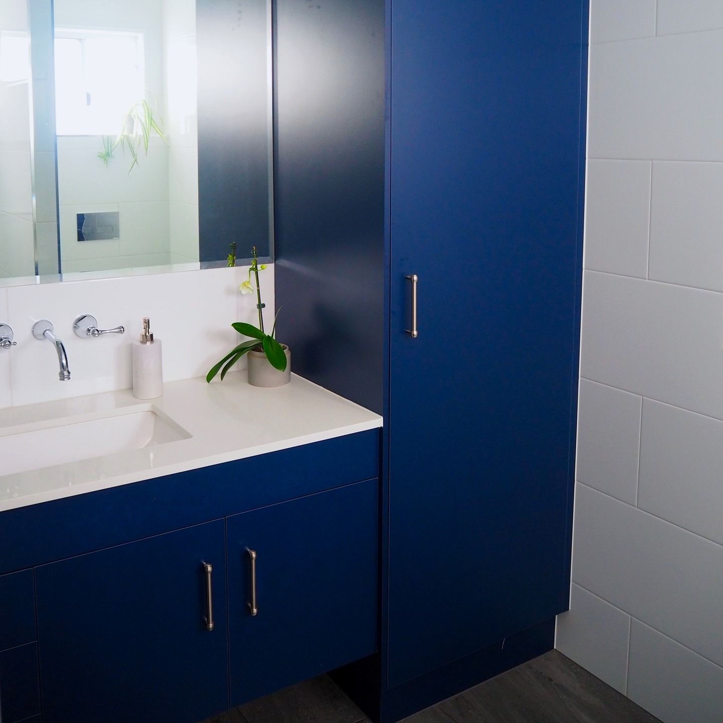 Blue Bathroom Vanity With Tall Storage Cabinet, White Countertop, and White Tile  — Payton Kitchens In Wilsonton, QLD