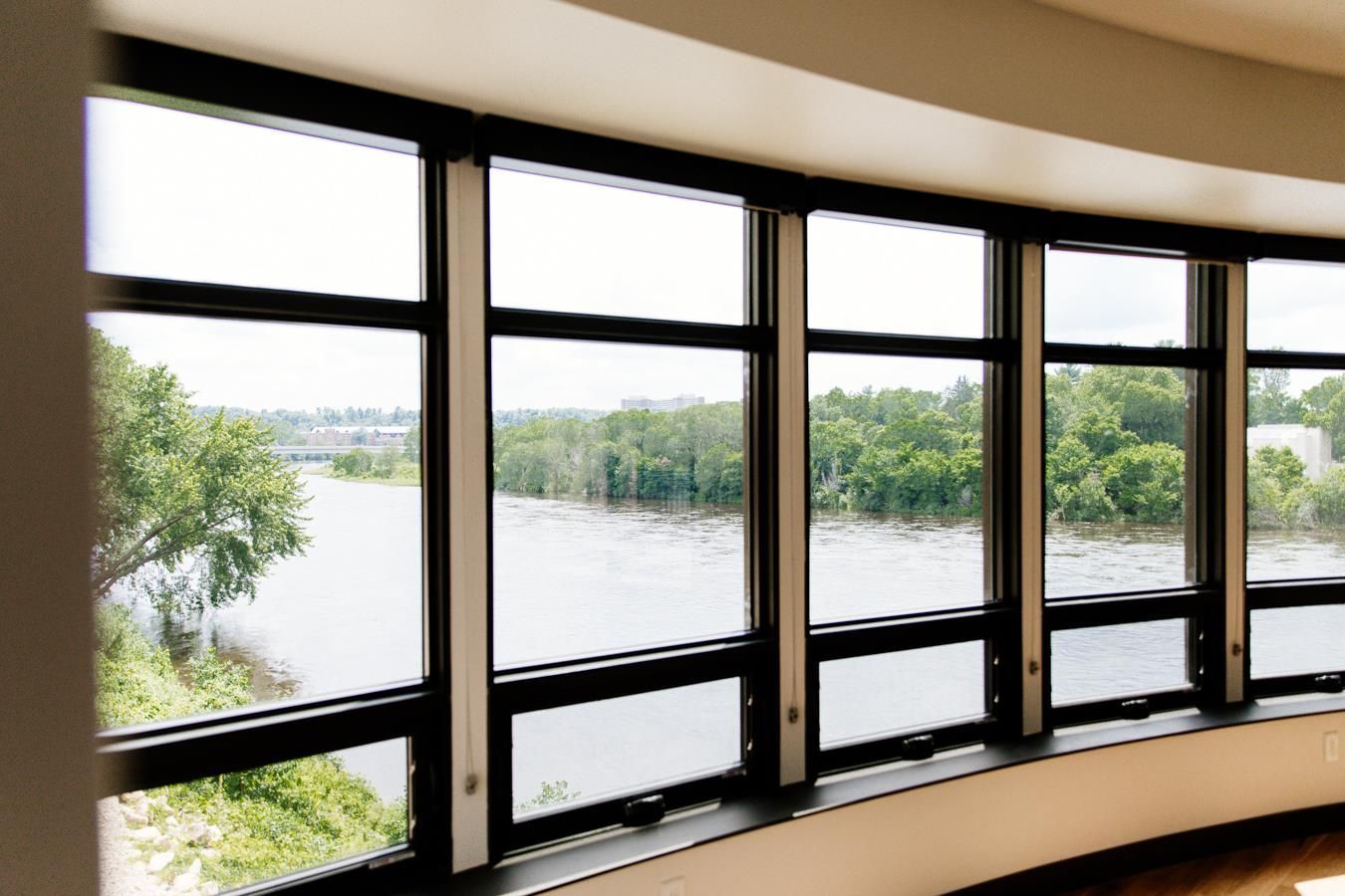A room with a lot of windows and a view of a river