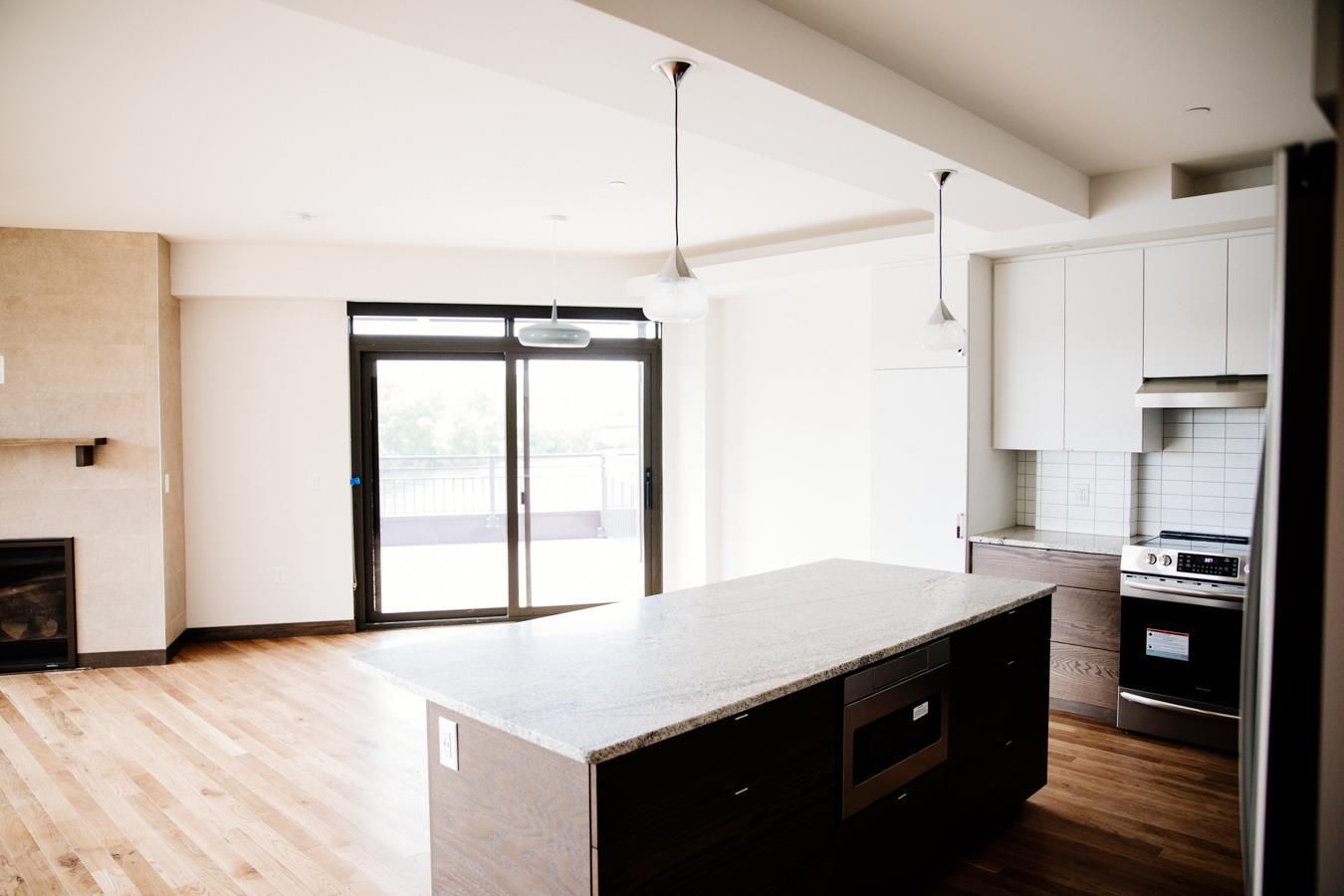 An empty kitchen with a large island in the middle