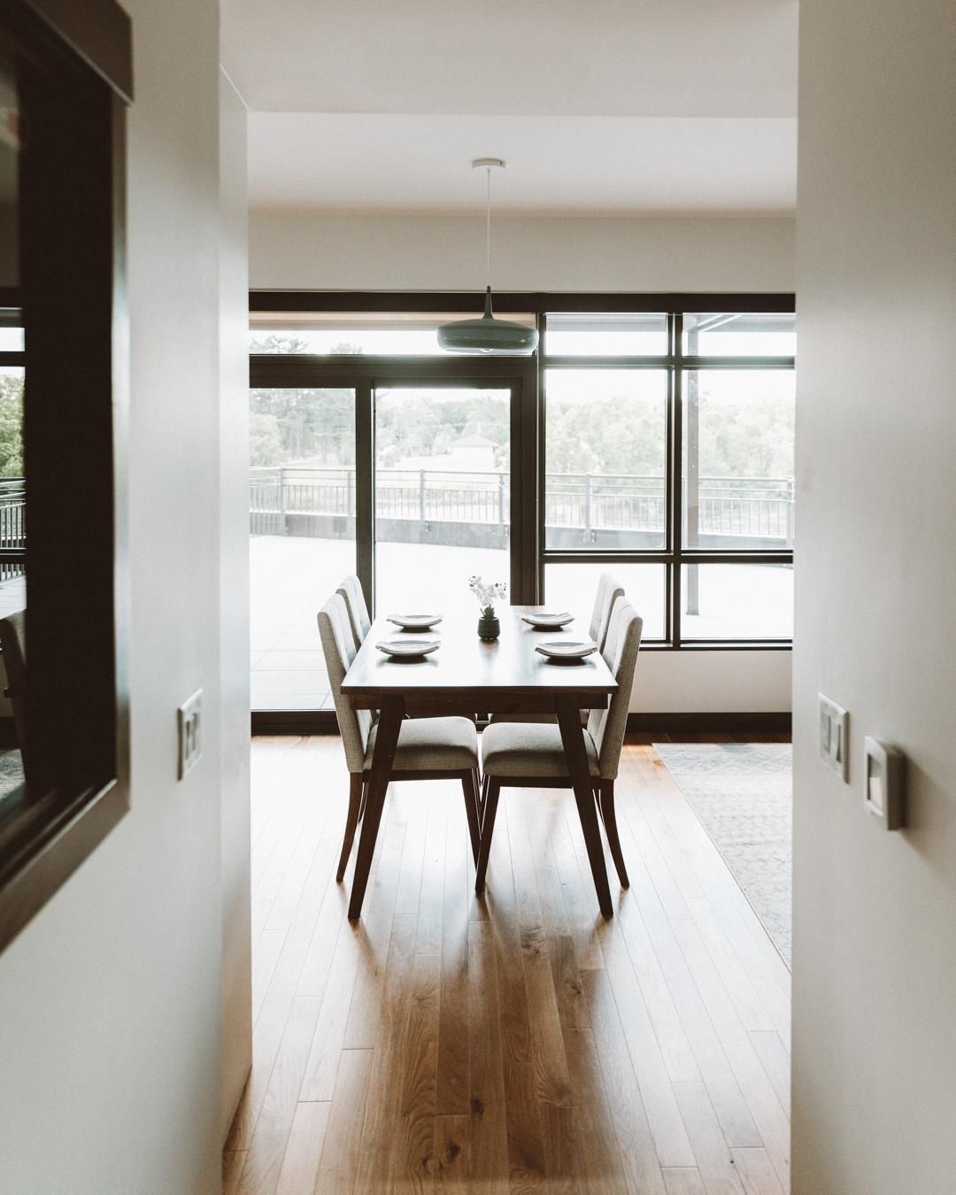 A hallway leading to a dining room with a table and chairs
