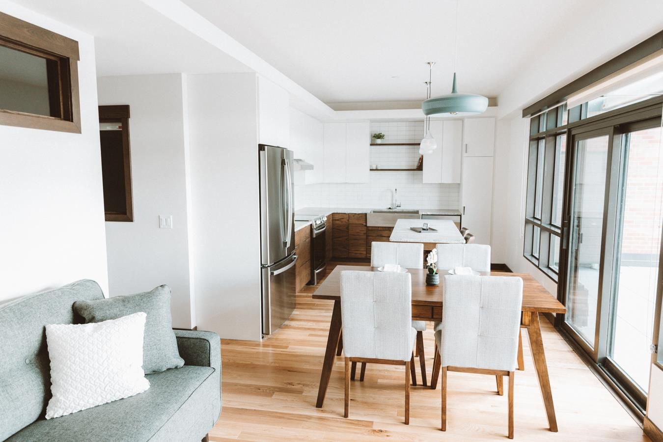 A living room with a couch , dining table and chairs.