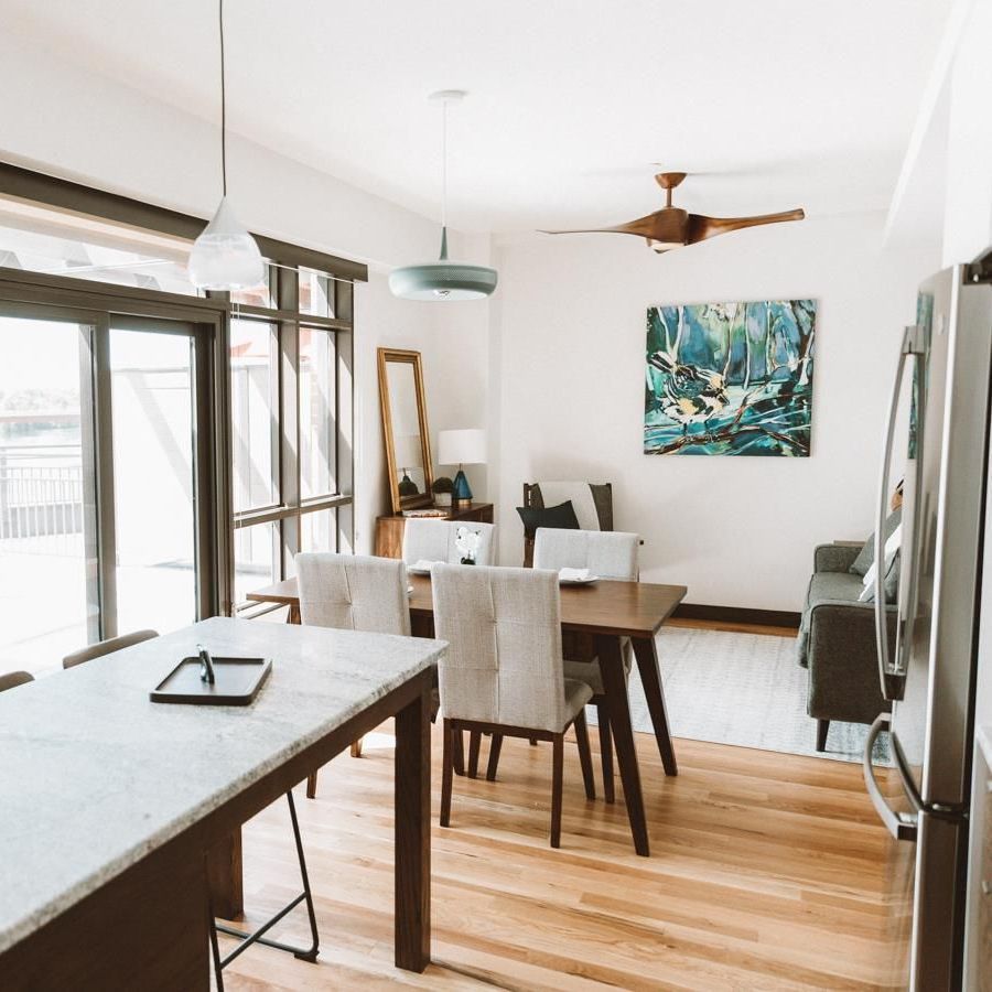 A living room with a table and chairs and a ceiling fan.