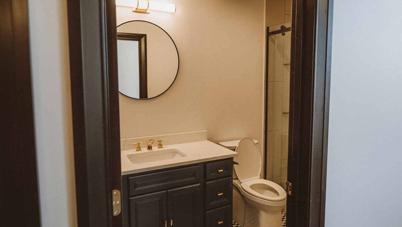 A bathroom with a sink , toilet , mirror and shower.