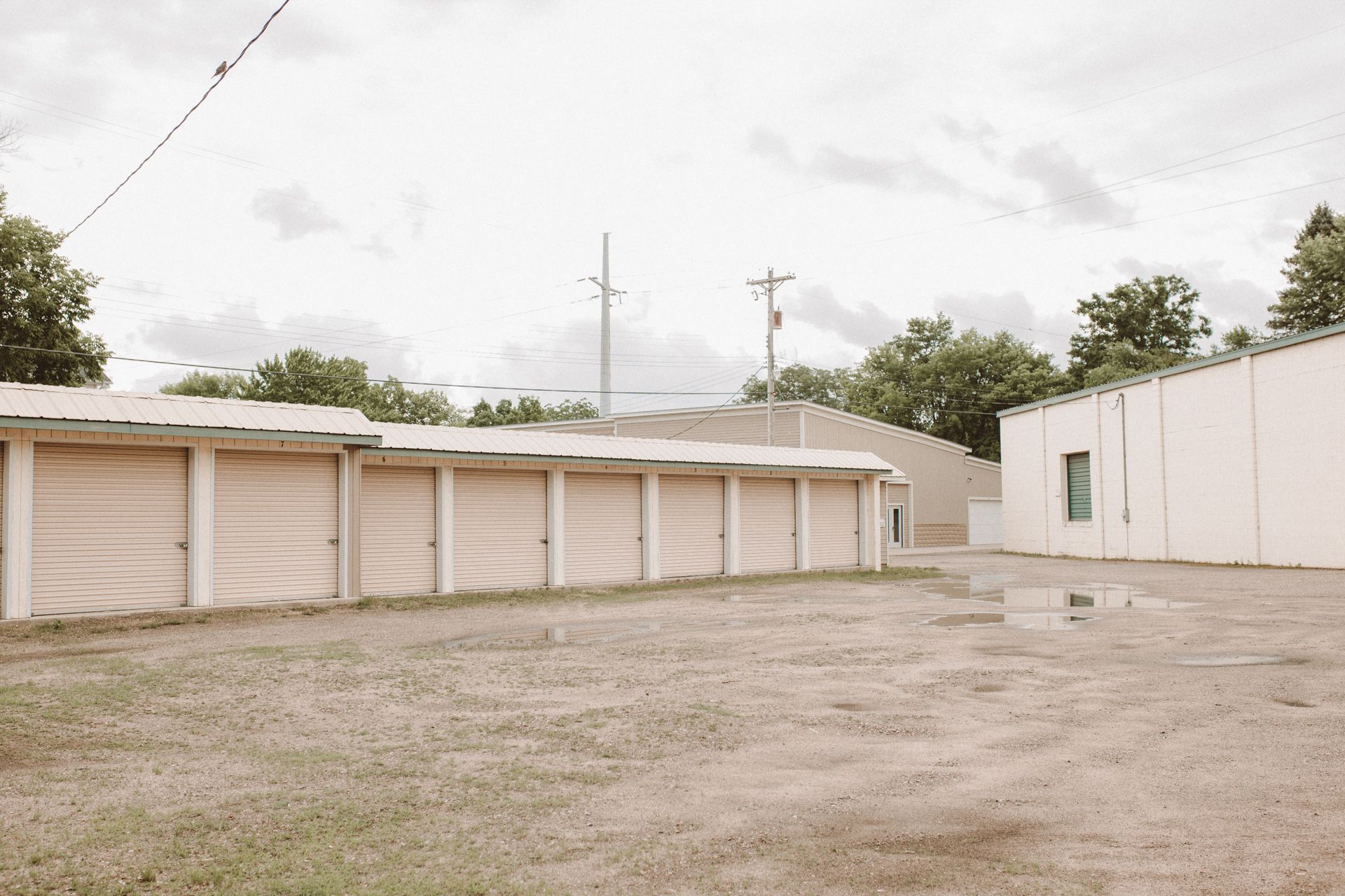 A row of garage doors in a parking lot next to a building.