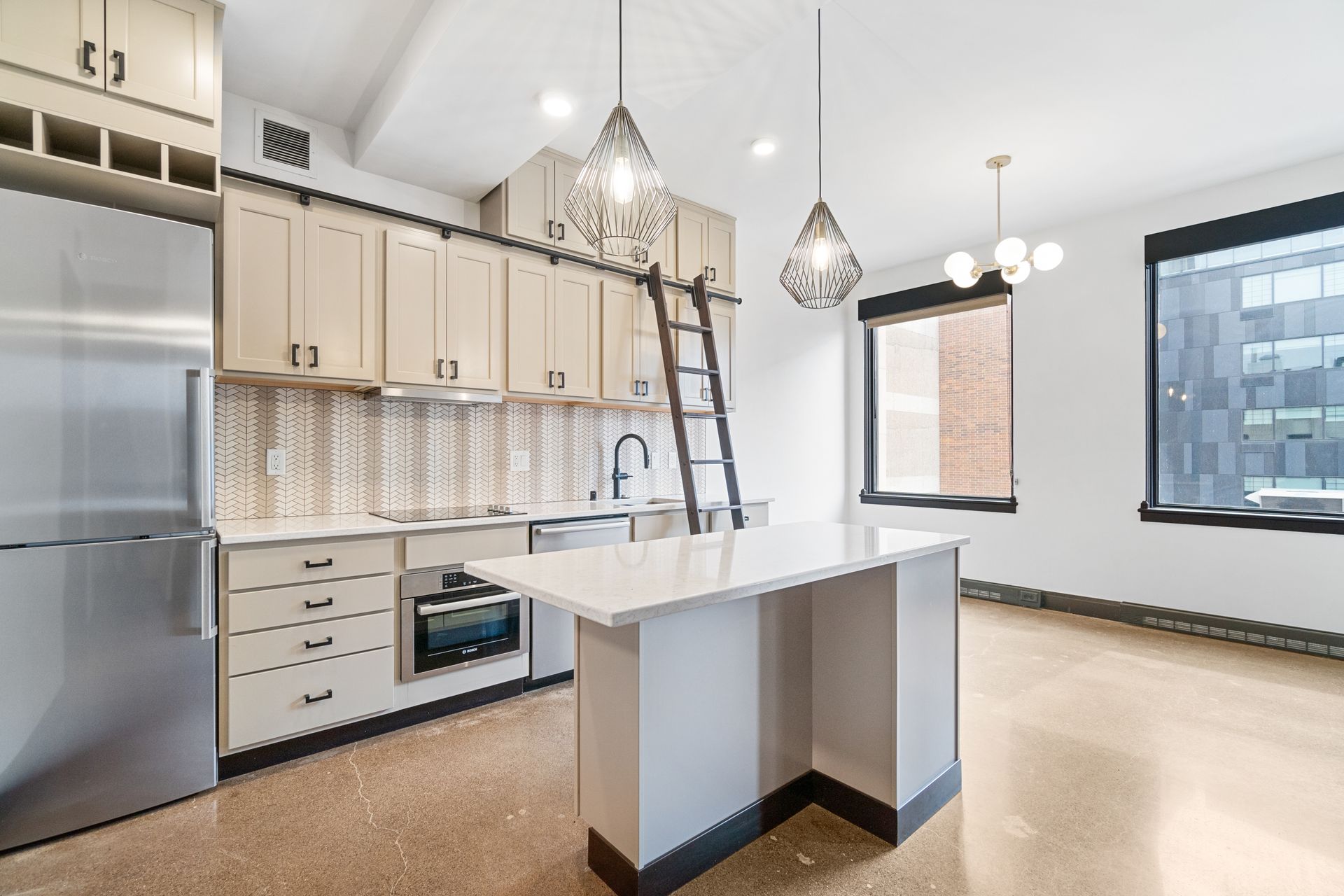 Modern kitchen with light cabinetry, stainless steel appliances, and island.