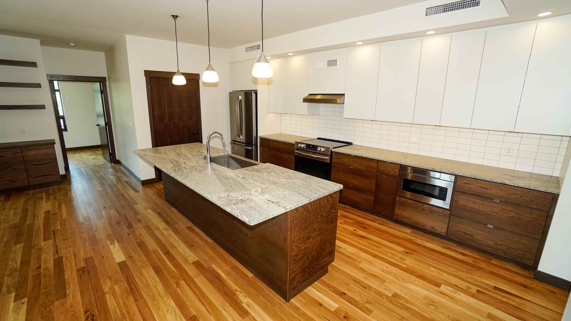 A kitchen with a large island in the middle and hardwood floors.