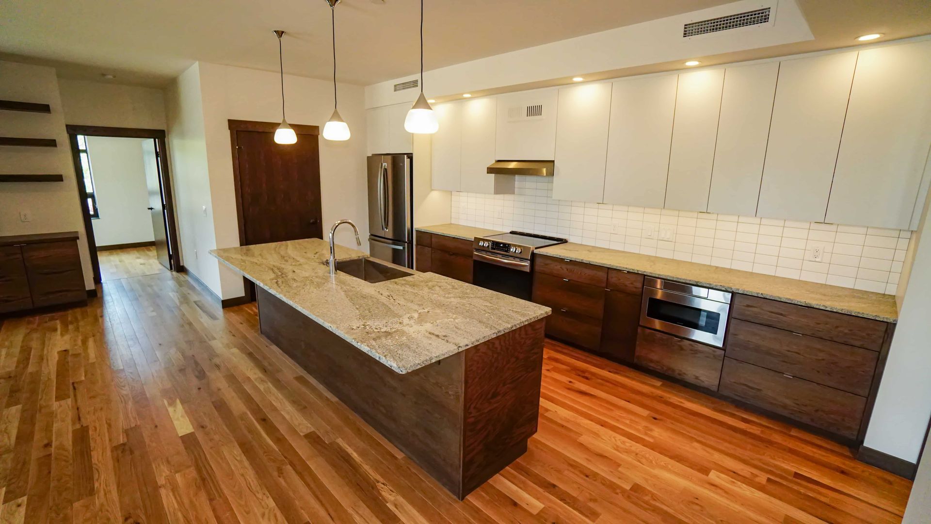 A kitchen with stainless steel appliances , granite counter tops , and hardwood floors.