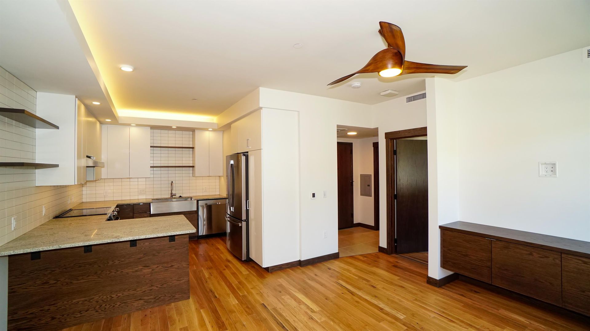 A living room with hardwood floors and a ceiling fan