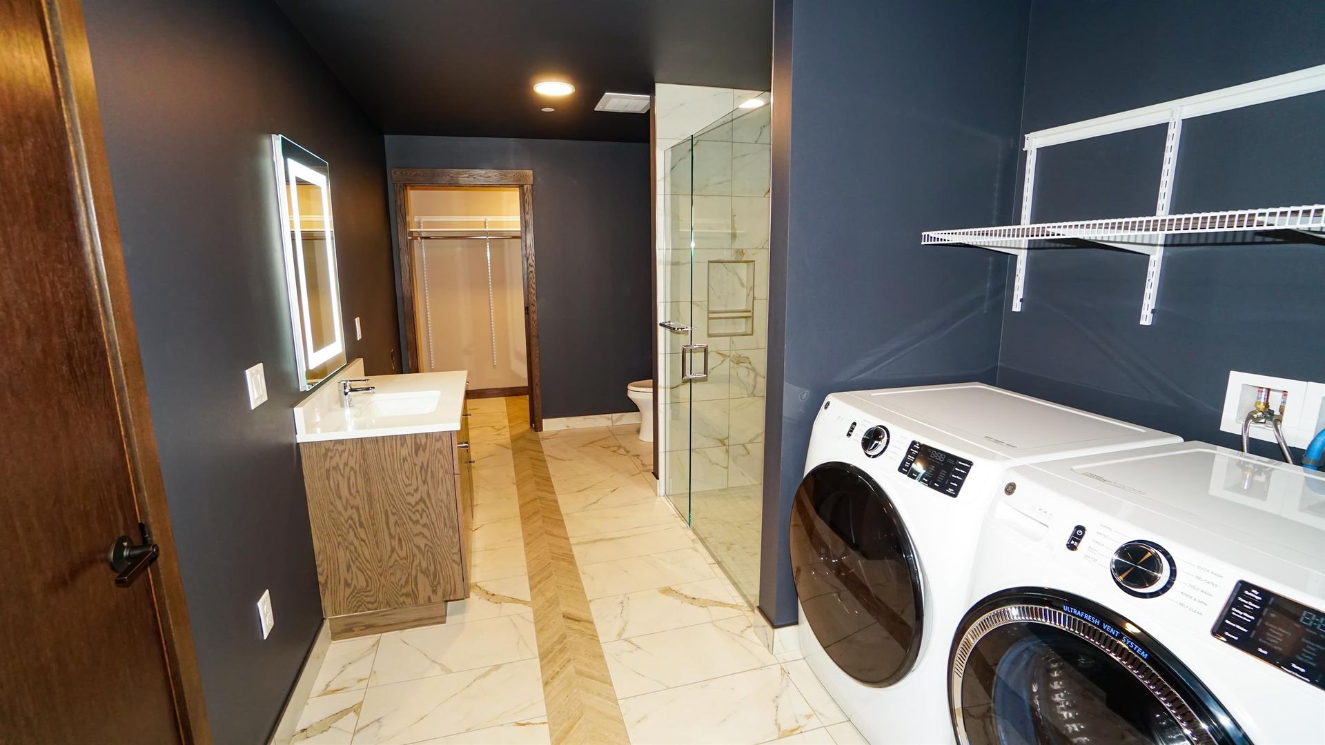 A laundry room with a washer and dryer and a bathroom.