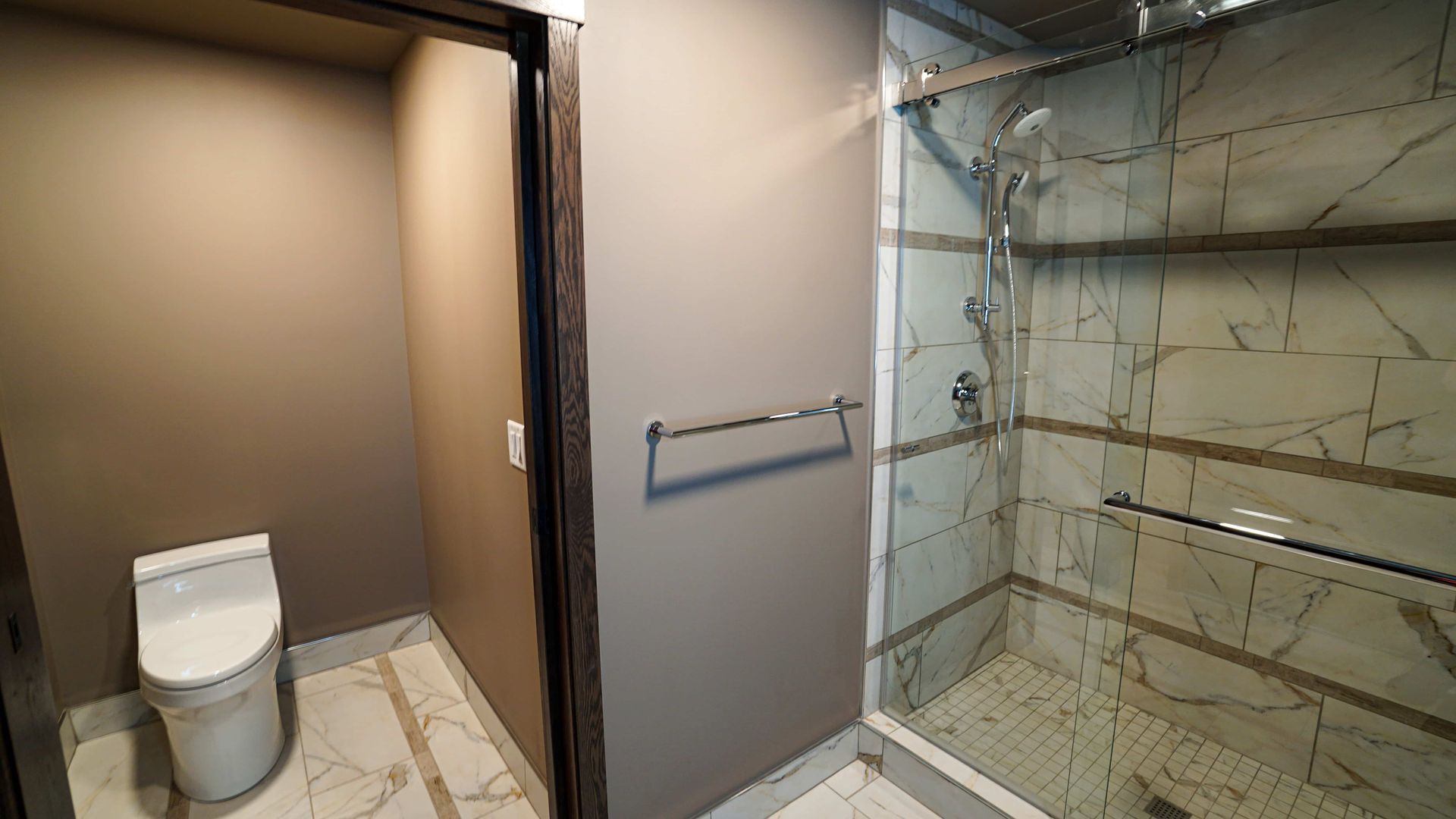 A bathroom with a toilet and a walk in shower.