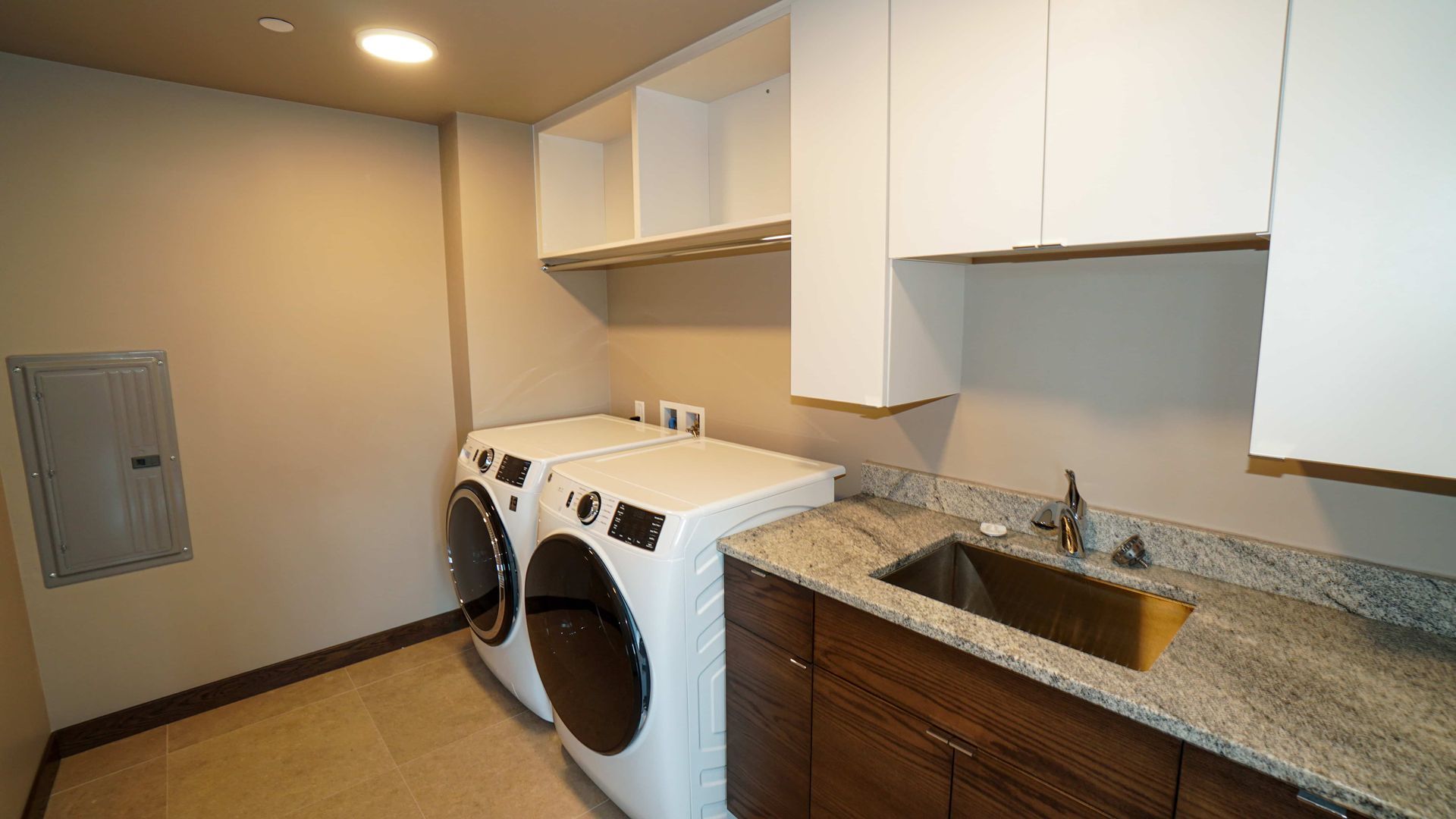 A laundry room with a washer and dryer and a sink.